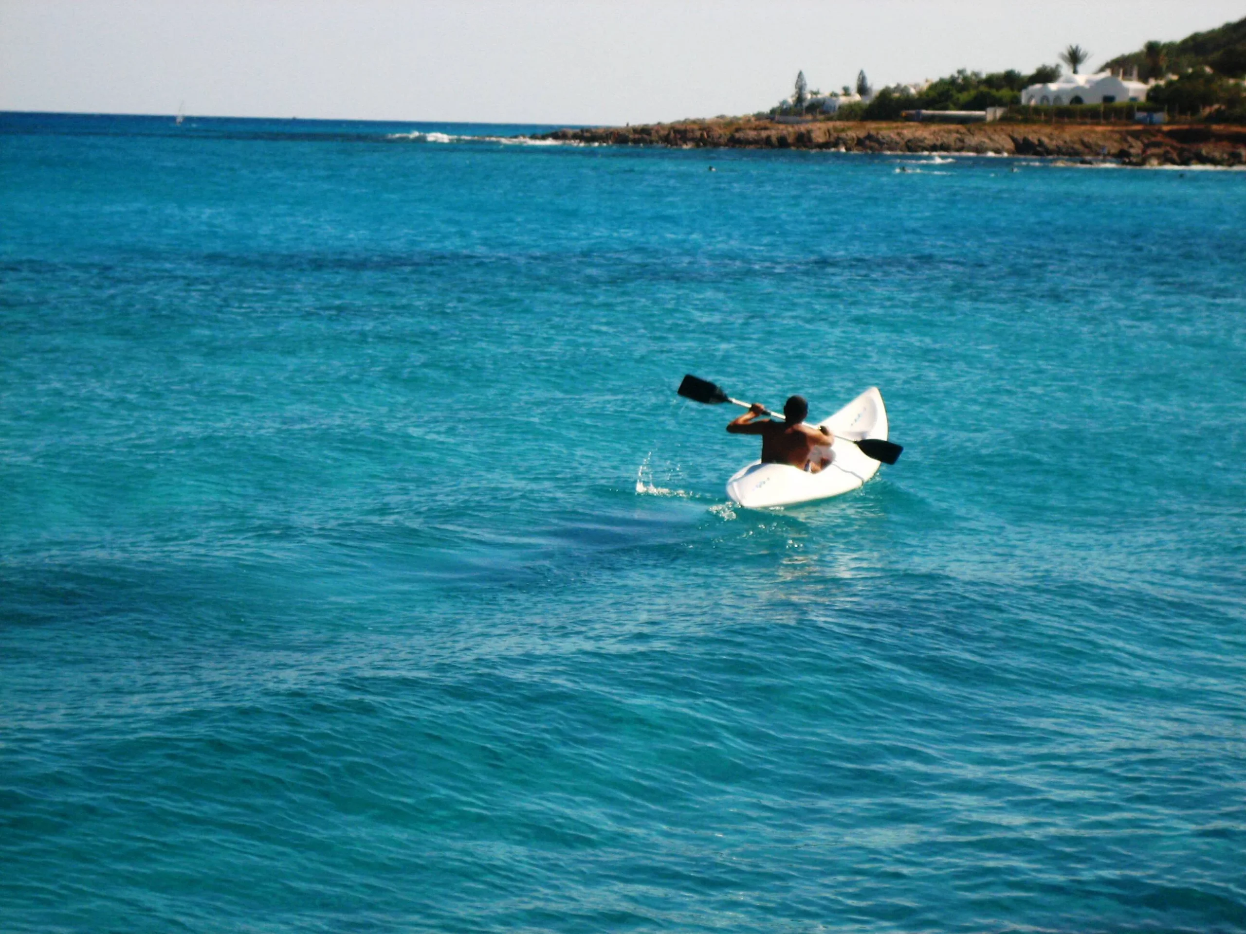 active adult paddling in turquoise ocean water- A Guide to Galapagos Adventure Travel and Multi-Sport Expeditions